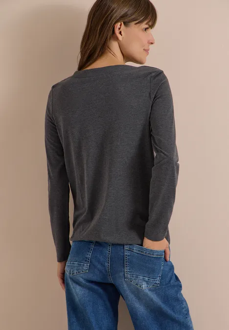 Langarm Shirt mit U-Boot-Ausschnitt black melange Frau von hinten in grauem Langarmshirt und lockeren blauen Jeans, Hände in den Taschen, braune Haare.
