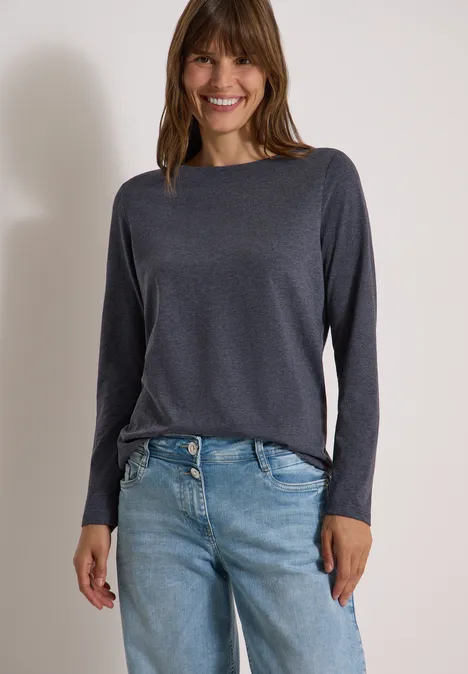 Langarm Shirt mit U-Boot-Ausschnitt urban dark blue melange Frau in grauem Langarmshirt und blauen Jeans lächelt vor hellem Hintergrund.