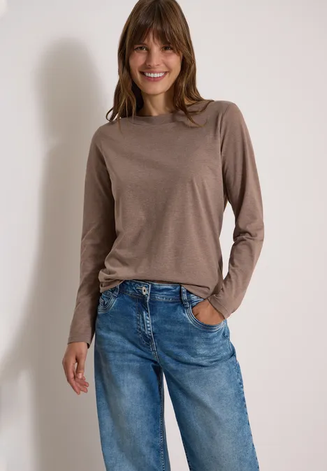 Langarm Shirt mit U-Boot-Ausschnitt urban taupe melange Frau mit braunem Langarmshirt und blauen Jeans lächelt in die Kamera.