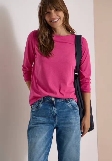 Langarm Shirt mit U-Boot-Ausschnitt pink flash melange Lächelnde Frau mit pinkem Langarmshirt, Jeanshose und Umhängetasche.