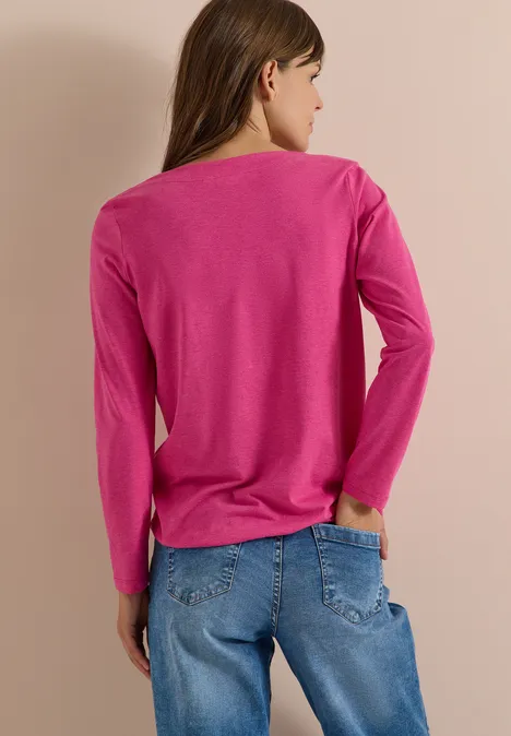Langarm Shirt mit U-Boot-Ausschnitt pink flash melange Frau steht von hinten in pinkem Langarmshirt und blauen Jeans vor hellem Hintergrund.