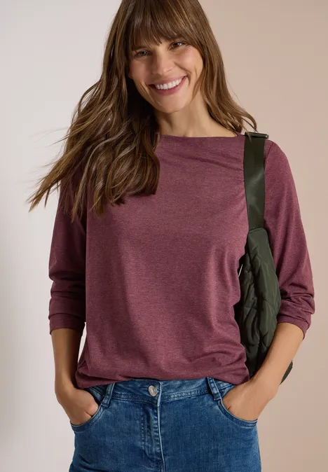 Langarm Shirt mit U-Boot-Ausschnitt red wine melange Frau in lila Shirt, Jeans und grünem Schulterbeutel lächelt in die Kamera