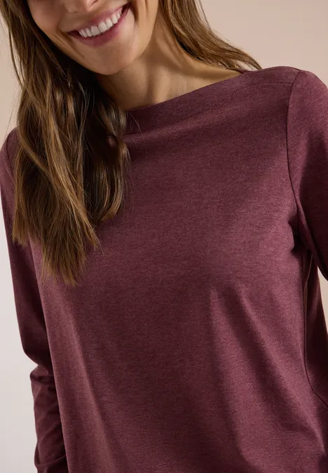 Langarm Shirt mit U-Boot-Ausschnitt red wine melange Eine Frau trägt ein burgunderfarbenes Langarmshirt und lächelt leicht.