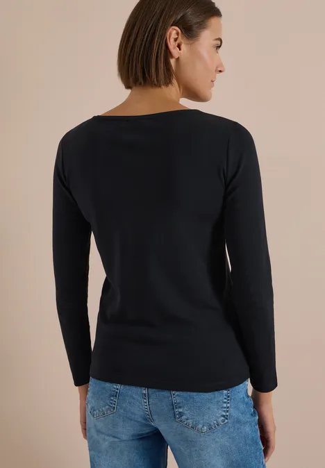 Langarm Shirt mit U-Boot-Ausschnitt Black Frau von hinten in schwarzem Langarmshirt und blauen Jeans.