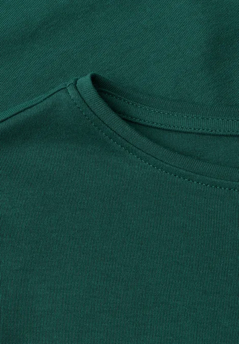 Nahaufnahme eines dunkelgrünen T-Shirt-Ausschnitts aus Baumwollstoff.