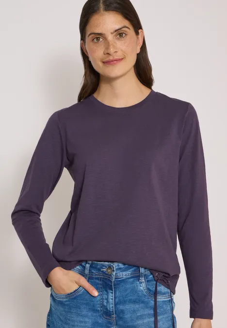Langarm Shirt mit Rundhals und Tunnelzug lilac shadow Eine Frau in dunkelviolettem Langarmshirt und Jeans vor hellem Hintergrund.