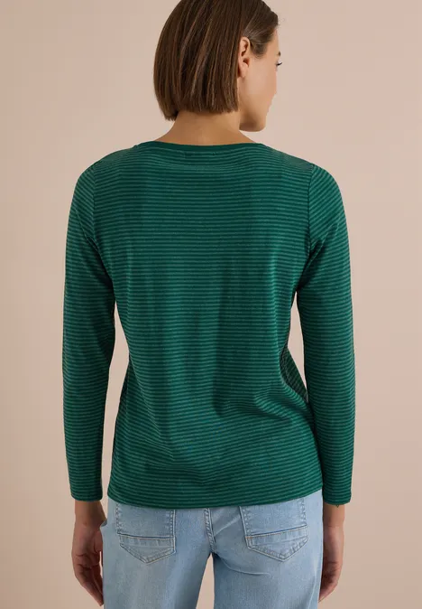 Langarm Shirt mit Boat Neck und Streifen dark fir green Rückenansicht einer Frau in grün geringeltem Langarmshirt und hellblauer Jeans vor beigem Hintergrund.