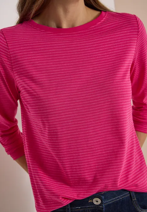 Langarm Shirt mit Boat Neck und Streifen pink flash Eine Person trägt ein pink gestreiftes Langarmshirt und blaue Jeans.