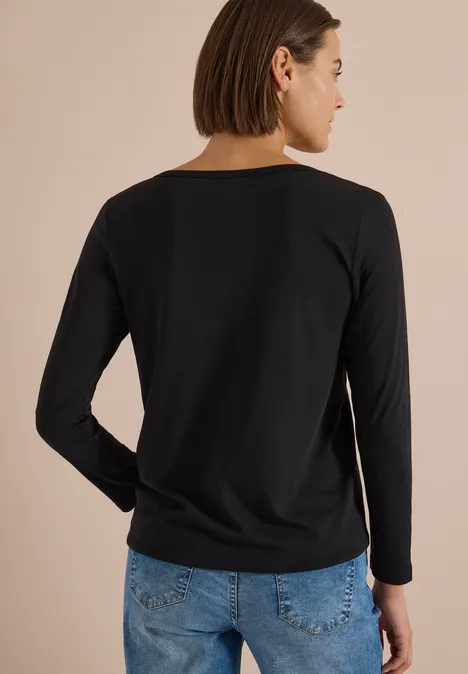 Shirt mit Split Neck im Tunika-Look Black Rückansicht einer Frau in schwarzem Langarmshirt und blauer Jeans.