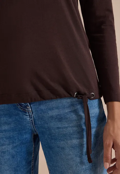 Shirt mit Split Neck im Tunika-Look truffle brown Teilsicht einer Person mit braunem Langarmshirt mit seitlichen Bändern und blauen Jeans.