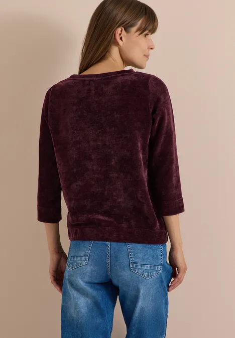T-shirt à manches 3/4 en velours côtelé avec encolure bateau berry red Femme de dos portant un pull mauve à manches 3/4 et un jean bleu.