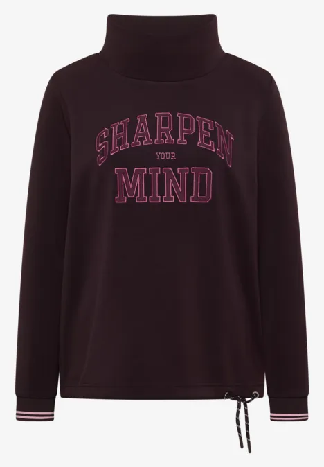 Dunkelvioletter Rollkragenpullover mit pinkem 'SHARPEN THE MIND'-Schriftzug, Saumkordel und gestreiften Bündchen.