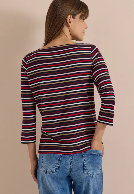 Frau von hinten in gestreiftem Langarmshirt und blauer Jeans.