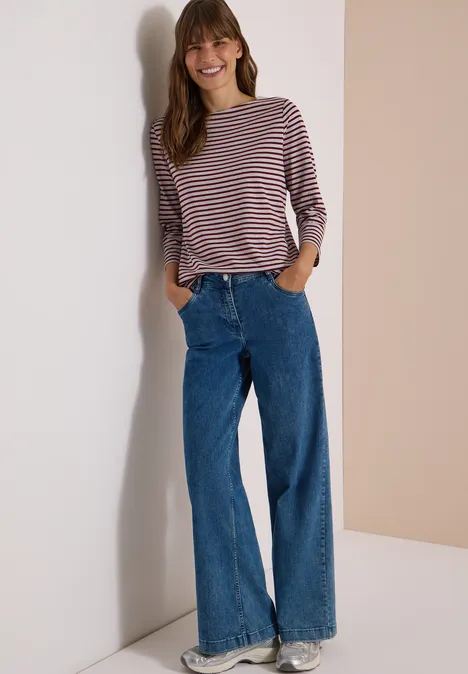 3/4-Arm Shirt mit Boat Neck und Streifen light grey melange Frau trägt lässiges gestreiftes Langarmshirt und weite Jeans vor neutralem Hintergrund.