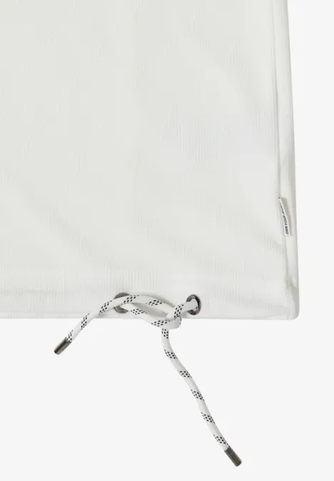 Weißes Textil mit Kordelzug und silberner Öse an der unteren Ecke eines Beutels.