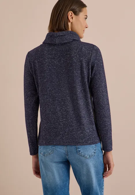 T-shirt souple à col et bande de renfort urban dark blue melange Rückenansicht einer Frau in dunkelblauem Strickpullover mit Rollkragen und hellen Jeans vor beigem Hintergrund.
