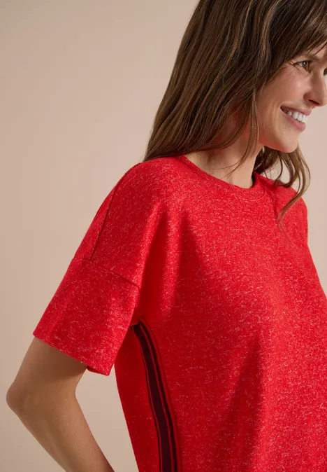 Shirt met verlaagde schouders, ronde hals en band flame red melange Frau in rotem kurzärmligem Pullover mit seitlichem Streifendetail, lächelnd im Profil.