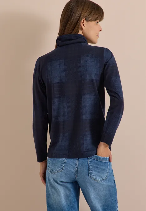 T-shirt à manches longues, col roulé et imprimé urban dark blue Femme de côté portant un pull à col roulé bleu à carreaux et un jean bleu.