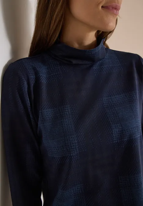 T-shirt à manches longues, col roulé et imprimé urban dark blue Gros plan d’une femme portant un tee-shirt à manches longues bleu foncé à col montant et motif à carreaux discret.