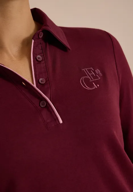 Bordeauxrotes Langarm-Poloshirt mit Knopfleiste und dezentem Monogramm-Logo auf der Brust.