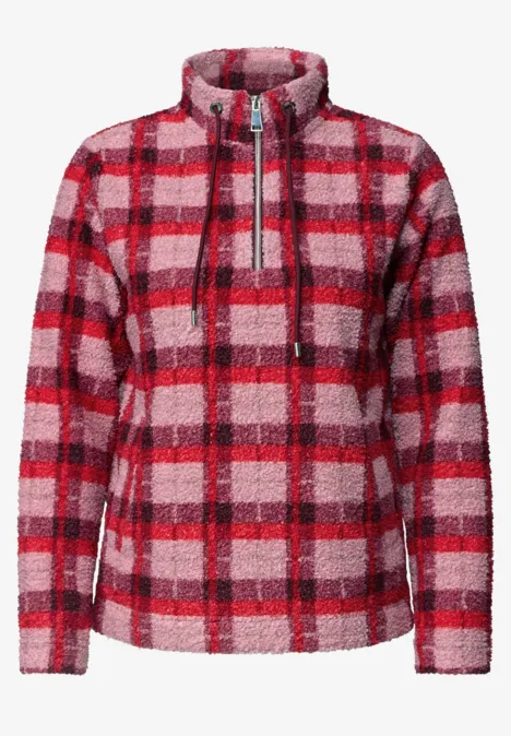 Rood-roze geruite fleecejas met opstaande kraag en ritssluiting.