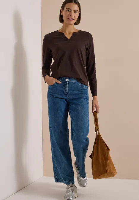 Langarm Shirt im Tunika-Look truffle brown Frau in brauner Bluse, weiten Jeans und weißen Sneakern hält eine braune Tasche.