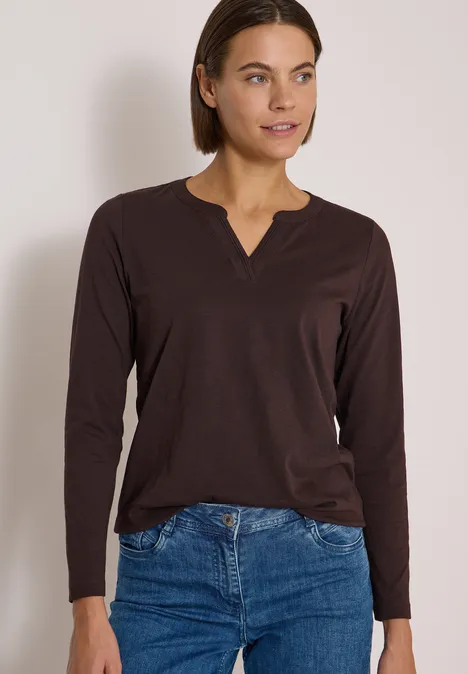 Langarm Shirt im Tunika-Look truffle brown Frau in braunem Langarmshirt und blauer Jeans, kurzhaarig, stehend und zur Seite blickend.