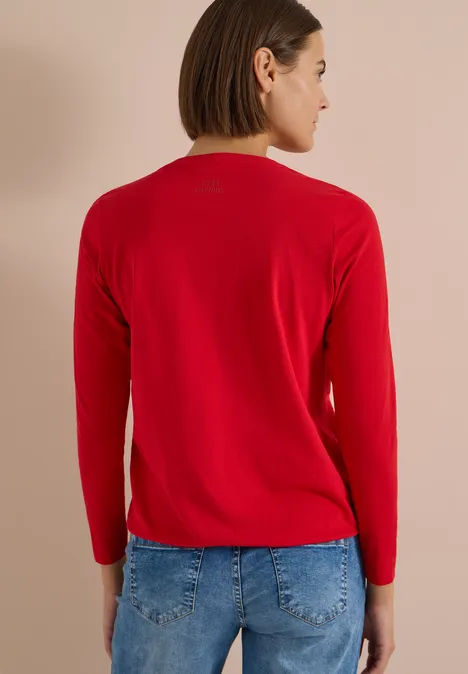 Langarm Shirt im Tunika-Look flame red Frau von hinten in rotem Langarmshirt und blauer Jeans vor neutralem Hintergrund.