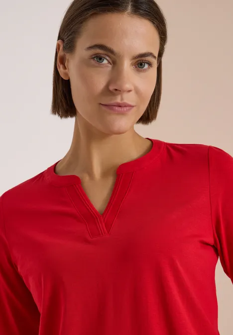 Langarm Shirt im Tunika-Look flame red Frau mit rotem Oberteil und schulterlangem braunem Haar