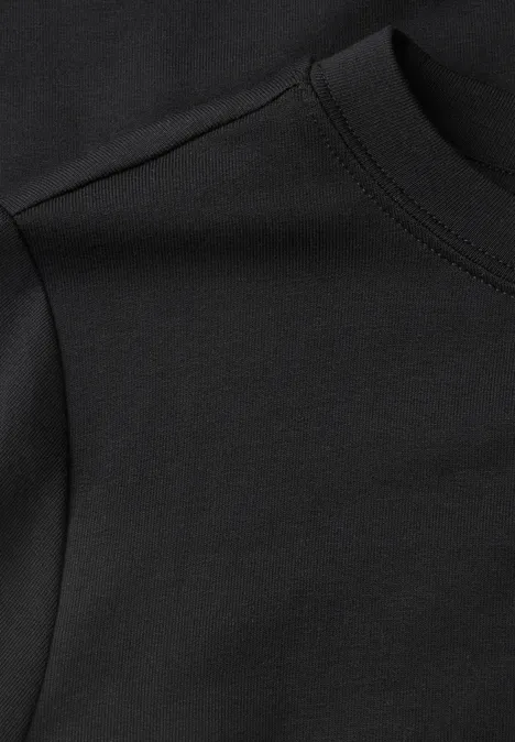Nahaufnahme eines schwarzen Baumwoll-T-Shirts, weicher Jersey und Rundhalsausschnitt mit sichtbarer Naht.
