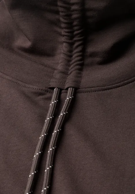 Close-up van een donkere hoodie met kangarozak en dikke, reflecterende koorden