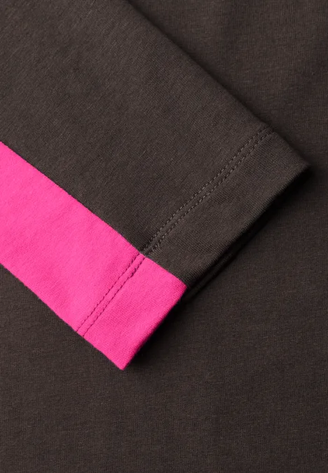 Gros plan d'un bas de manche noir avec un liseré rose.