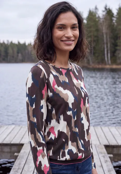 T-shirt à manches longues, col bateau et imprimé pink flash Eine Frau im bunten Pullover steht an einem Steg vor einem ruhigen Waldsee.