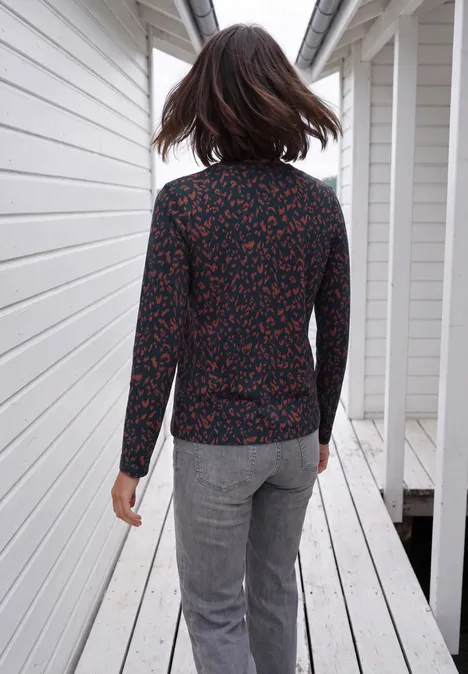 Shirt mit Split Neck im Tunika-Look urban dark blue Frau von hinten in gepunkteter Bluse und grauer Hose auf einem weißen Holzsteg.