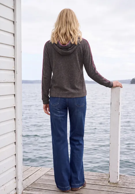 T-shirt à manches longues avec capuche et passepoil truffle brown melange Eine Frau von hinten in Kapuzenpullover und Schlagjeans steht auf einem Steg am ruhigen See.