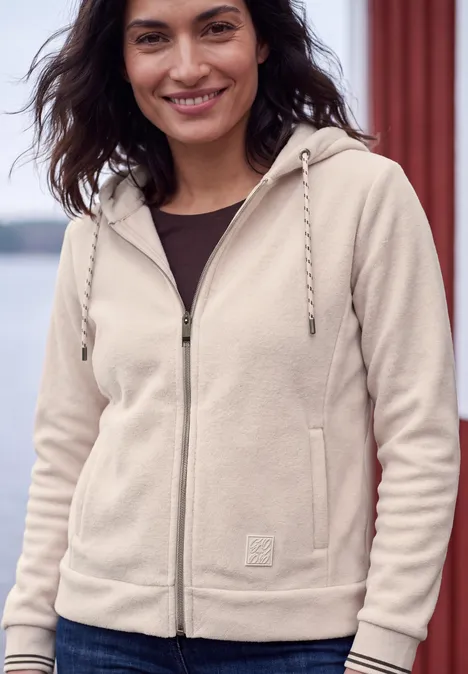 Langarm Fleece Jacke mit Kapuze cashmere beige Eine lächelnde Frau trägt einen beigen Reißverschluss-Hoodie mit Kordelzug und Taschen.