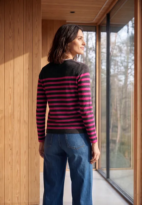T-shirt rayé à manches longues et col bateau truffle brown melange Eine Frau in gestreiftem Pullover steht innen vor einem Fenster und blickt in einen Wald