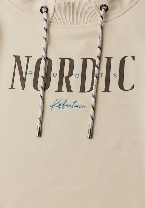 Nahaufnahme eines beigen Hoodies mit NORDIC-Print und blauem København-Schriftzug, geflochtene Kordeln.