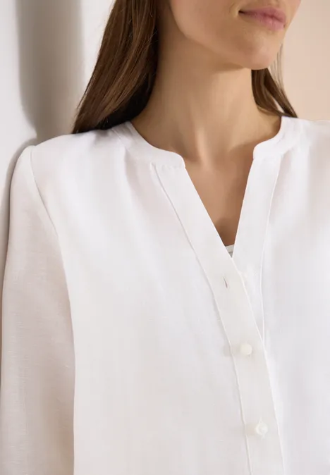 Witte blouse met lange mouwen, V-hals en knopenlijst.