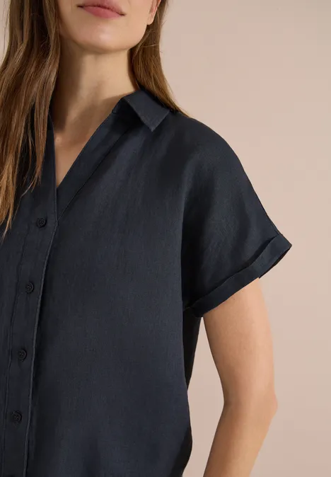Donkerblauw linnen overhemd met korte mouwen, kraag en knoopsluiting, losvallende pasvorm.