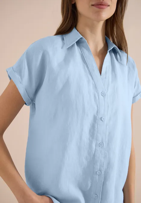 Lichtblauw dameslinnenblouse met korte mouwen en knoopsluiting.