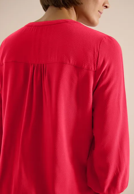 Vue de dos d'une personne portant un haut rouge à manches longues.