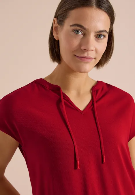 Een rood T-shirt met korte mouwen en capuchon.