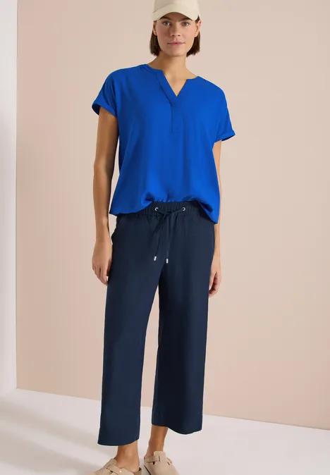 Blouse met korte mouwen en gespleten hals surf blue Vrouw in kobaltblauw V-shirt met tunnelkoord en marineblauwe wijde culotte.