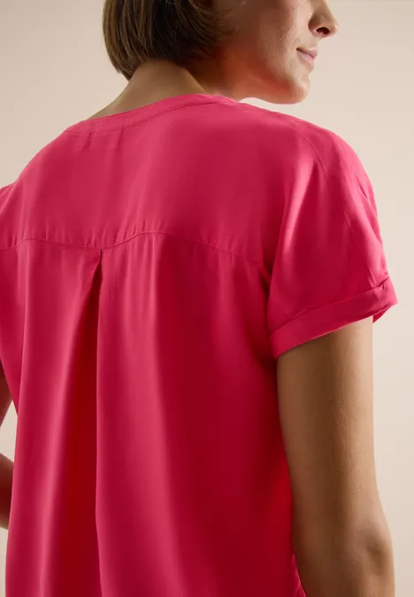 Blouse met korte mouwen en gespleten hals geranium red Achteraanzicht van een persoon met een roze T-shirt met korte mouwen tegen een lichte achtergrond.