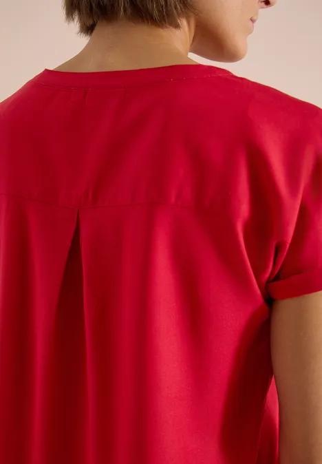Rückansicht eines roten T-Shirts mit kurzen Ärmeln und Kellerfalte am Rücken.