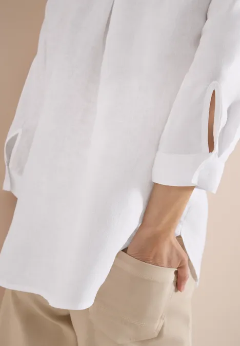 3/4-Arm Tunika aus reinem Leinen White Weiße Bluse mit 3/4-Ärmeln und beigen Hosen, Hand in Hosentasche.