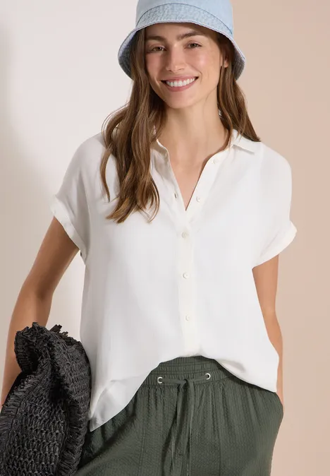 Kurzarm Hemdbluse in Unifarbe vanilla white Frau in weißem Kurzarm-Hemd, grünem Bundfaltenhose, hellblauem Fischerhut, schwarzem Strohhut in der Hand