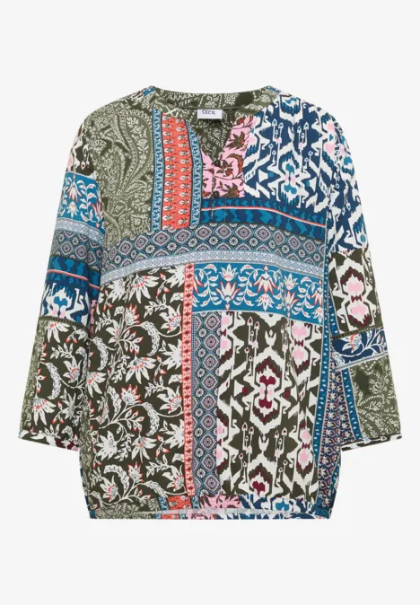 Losvallende damesblouse met kleurrijk patchwork- en bloemenpatroon, lange mouwen.