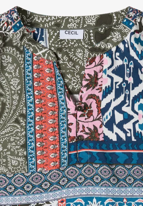 Opgevouwen damesblouse met kleurrijk patchworkmotief.